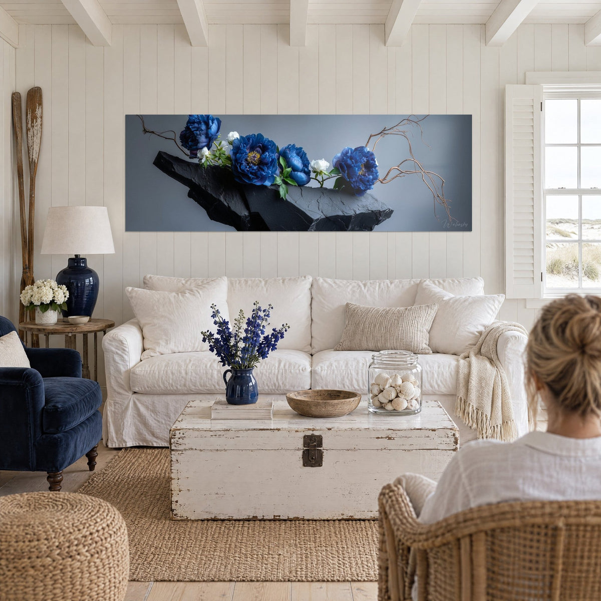 Wall art cobalt blue peonies on black slate, copper branches, grey background, above a sofa in a bright living room