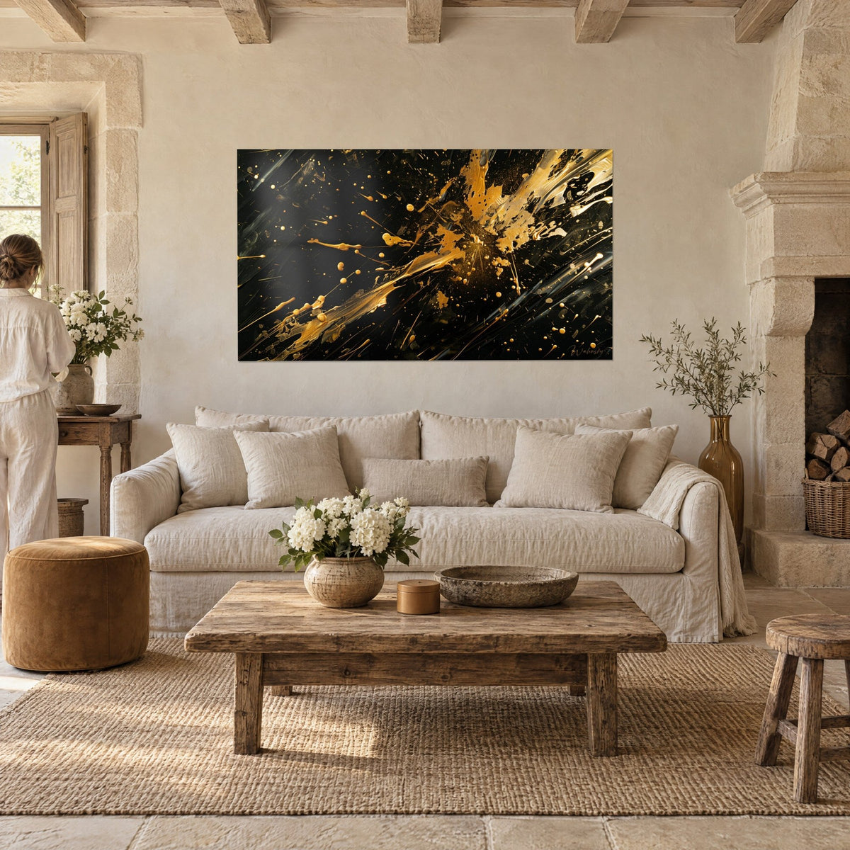 Wall art explosive golden paint splash on black background, woman seen from behind, above a sofa in a bright living room