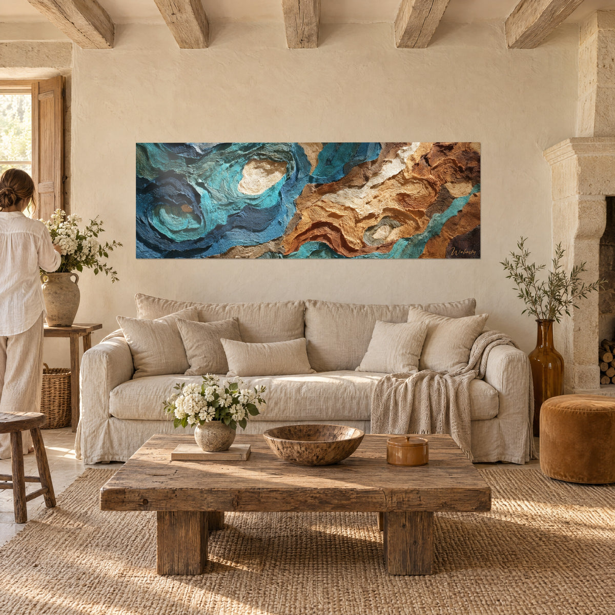 Tableau vagues océaniques en relief texturé, turquoise et ocre cuivré, au-dessus d'un canapé dans un salon lumineux