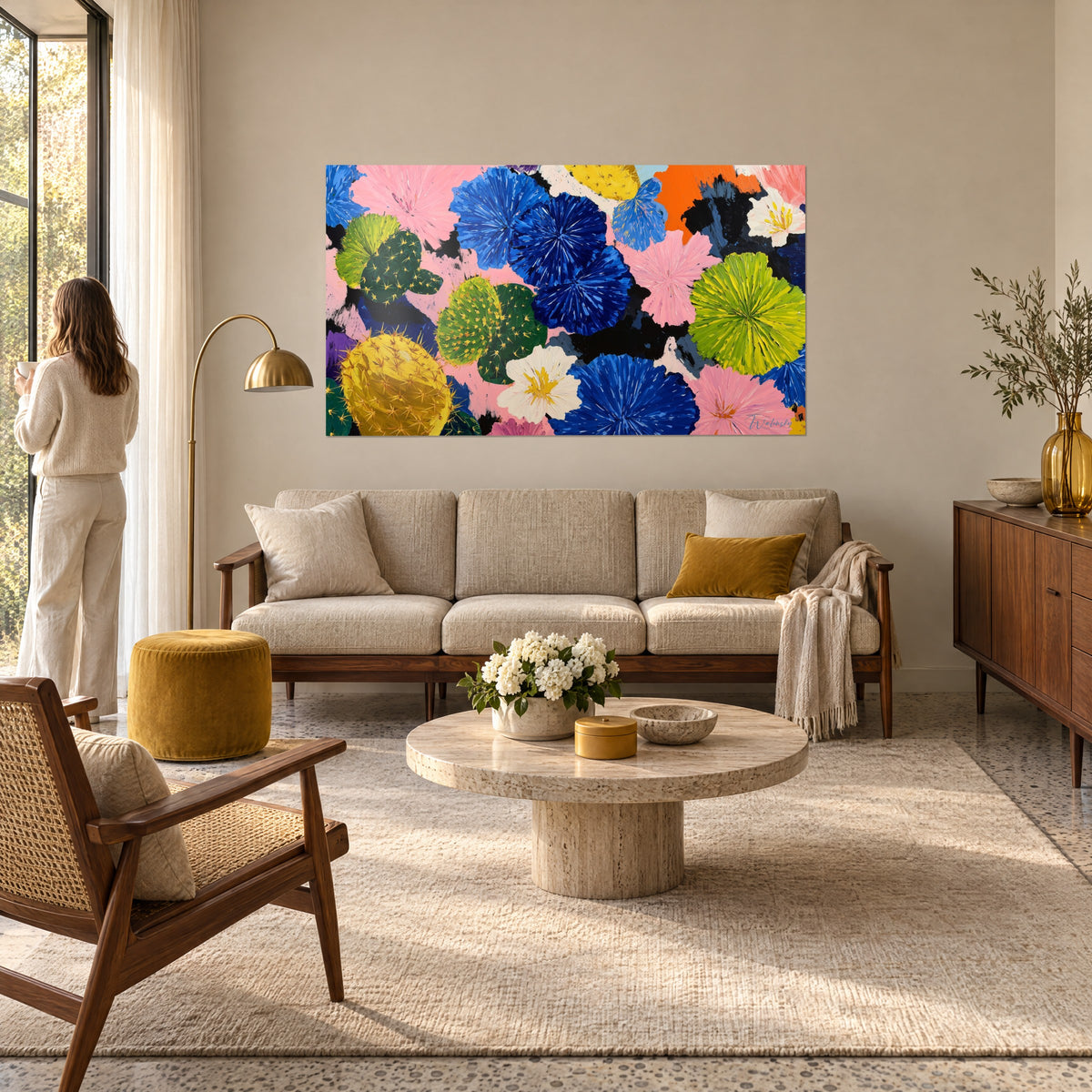 Gemälde mit blühenden Kakteen und kobaltblauen Pompons auf puderrosa Grund, über einem Sofa in einem hellen Wohnzimmer