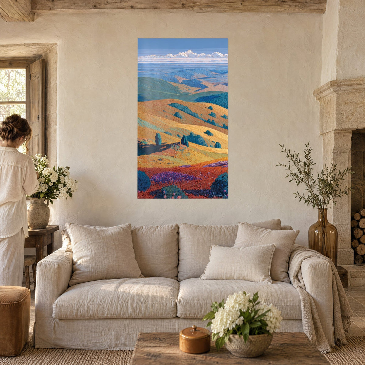 Schilderij gouden heuvels onder een blauwe lucht, oranje en paarse weide op de voorgrond, boven een bank in een lichte woonkamer