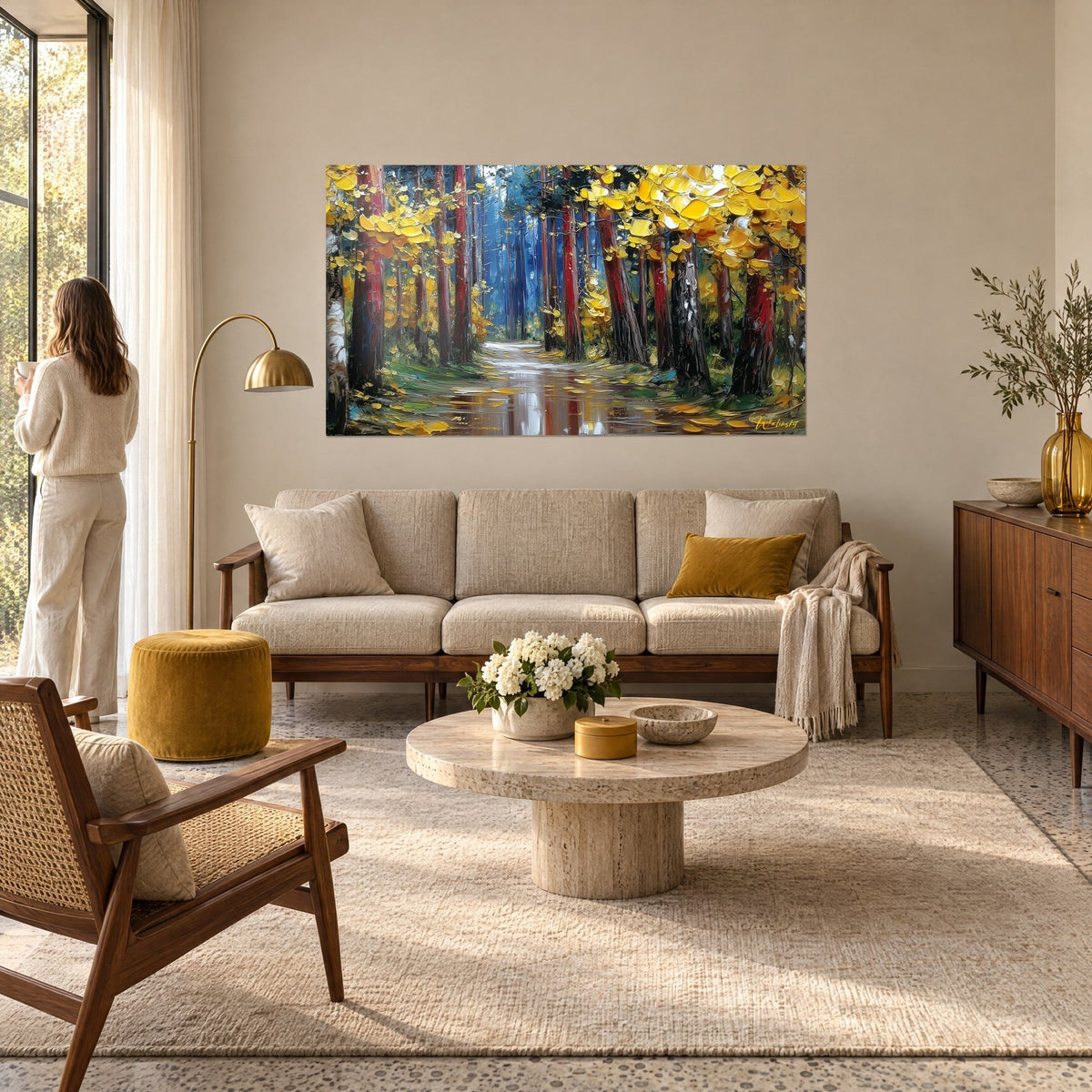 Wall art forest path with golden-yellow foliage and red trunks on a blue background, above a sofa in a bright living room