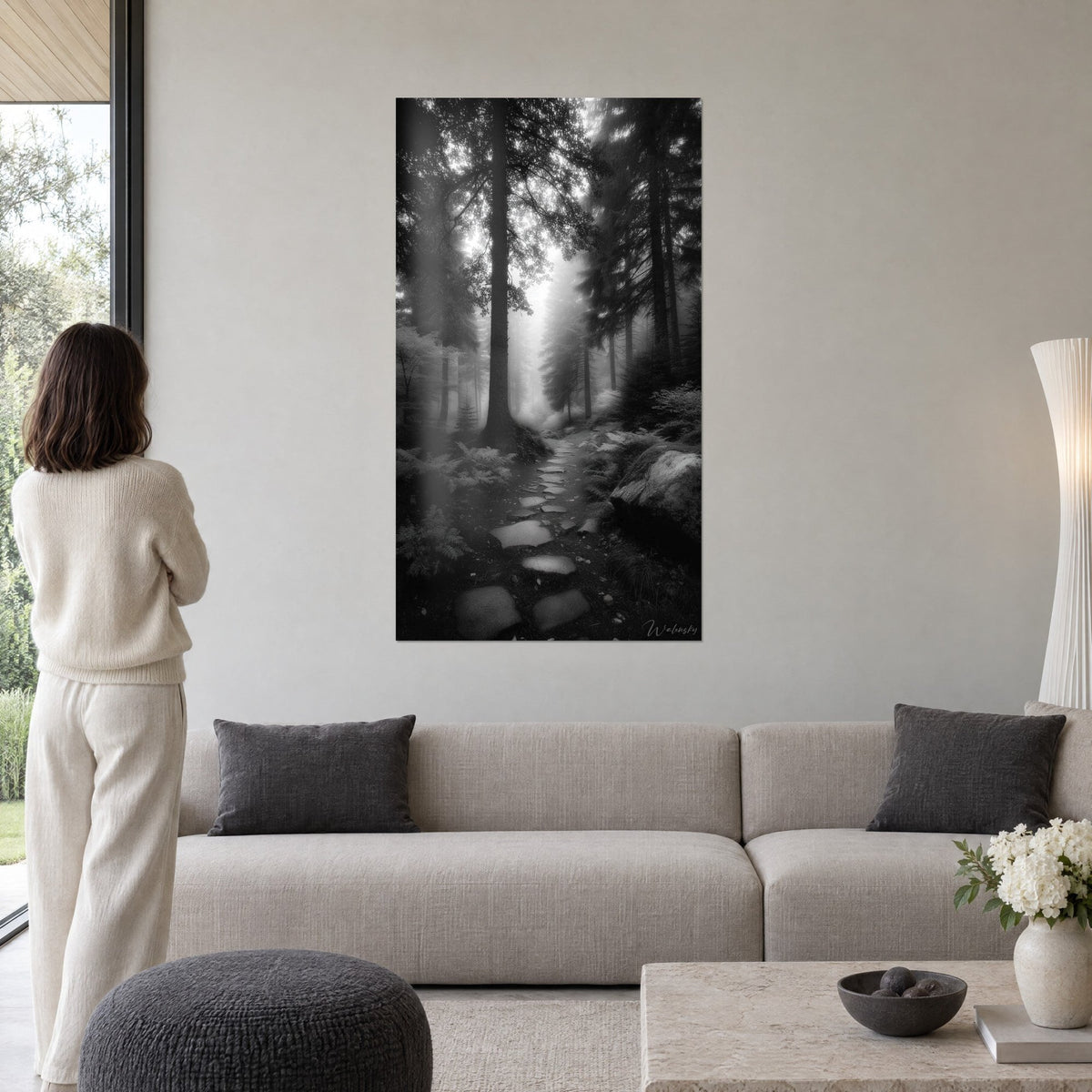 Tableau sentier de pierre dans la brume, troncs noirs et fougères gris perle, au-dessus d'un canapé dans un salon lumineux