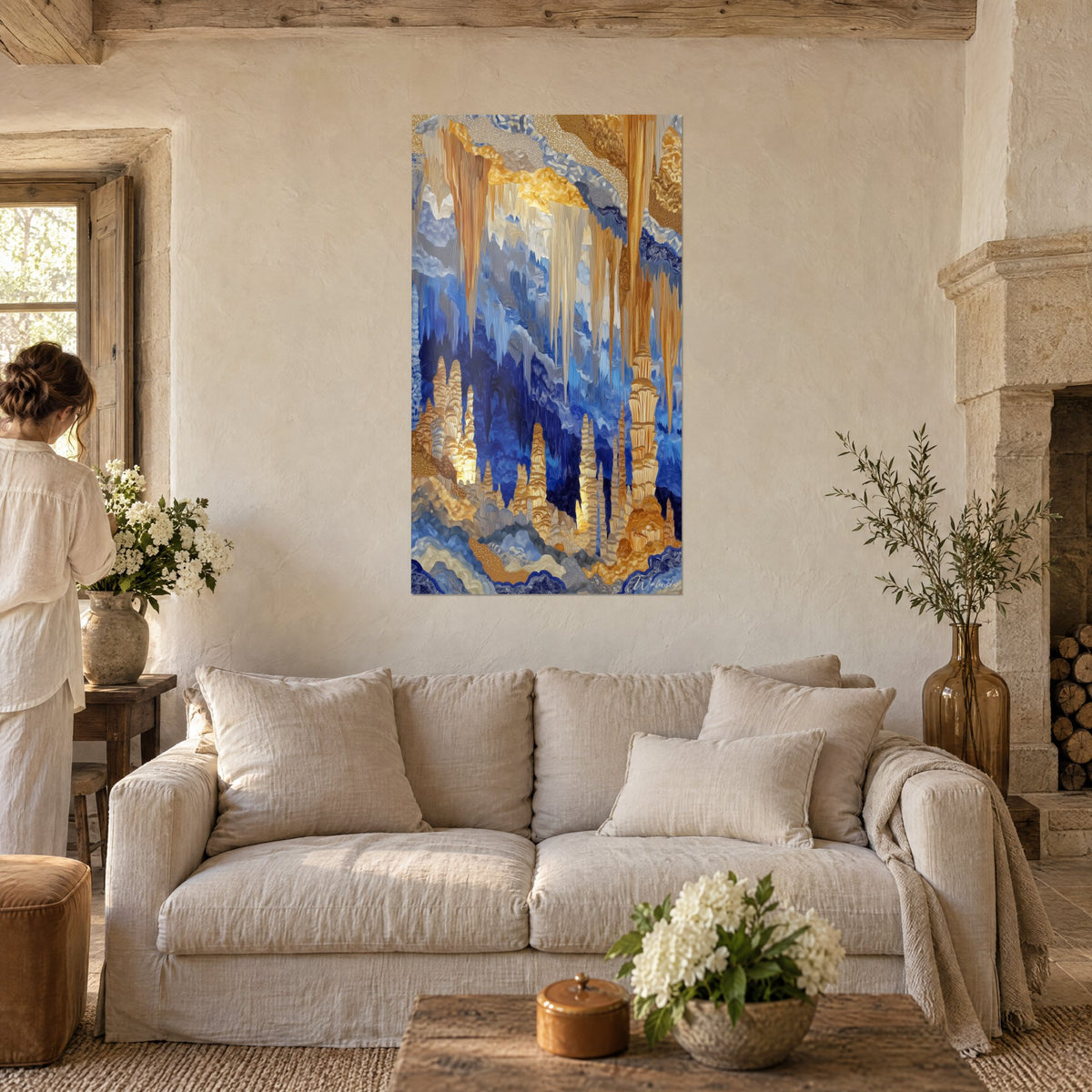 Tableau grotte aux stalactites dorées et bleu cobalt, deux personnes de dos, au-dessus d'un canapé dans un salon lumineux