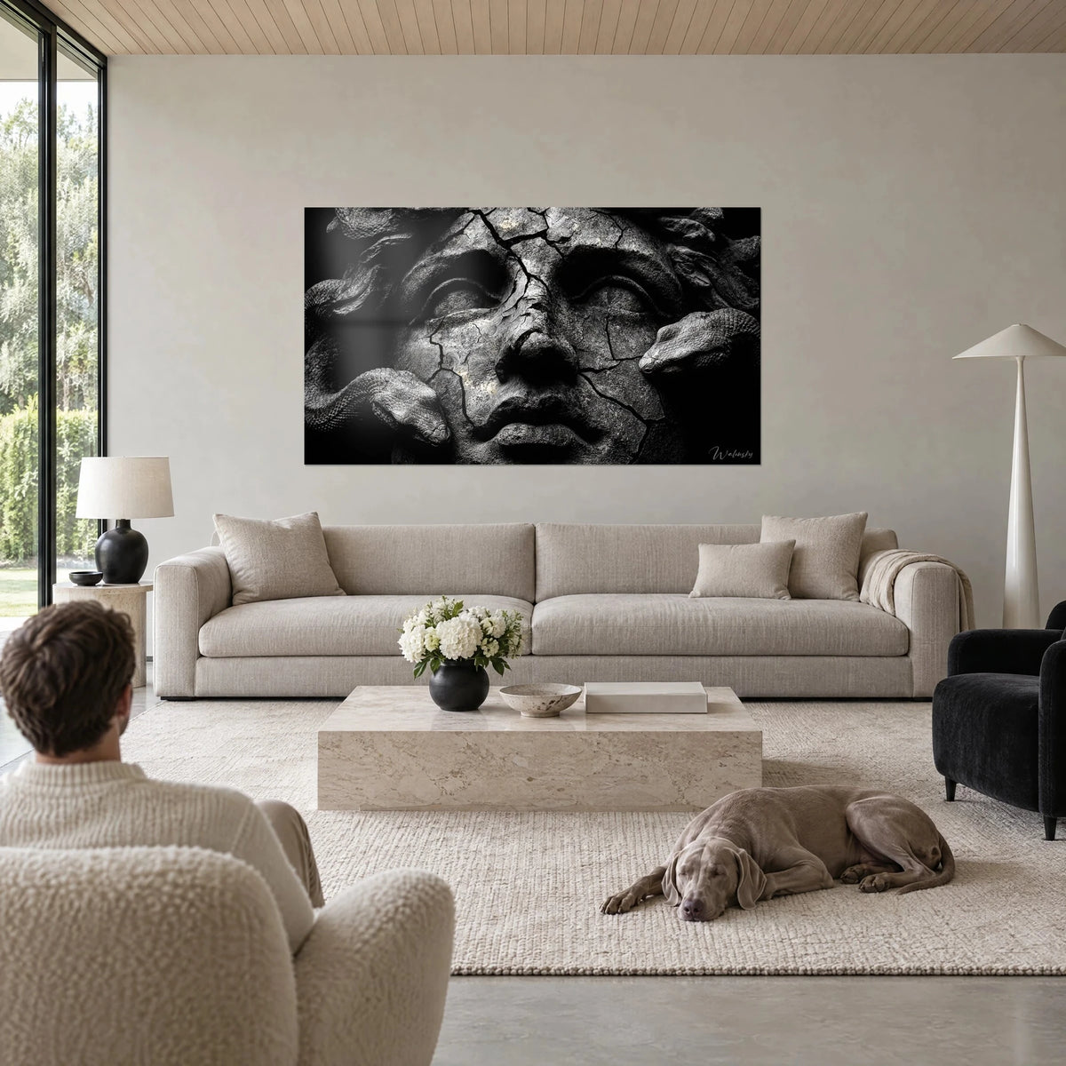 Gemälde Medusa aus rissigem Stein, graue Schlangen und schwarzer Hintergrund, ein Mann und ein Weimaraner, über einem Sofa in einem hellen Wohnzimmer