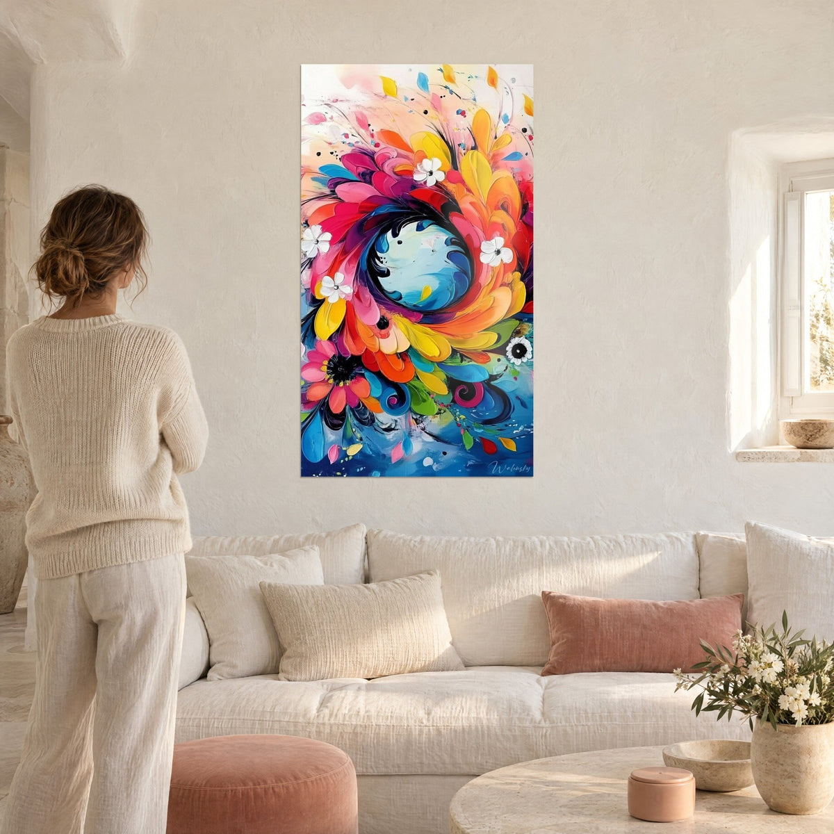 Tableau explosion florale en spirale rose, orange et turquoise, pétales épais, femme de dos, au-dessus d'un canapé dans un salon lumineux