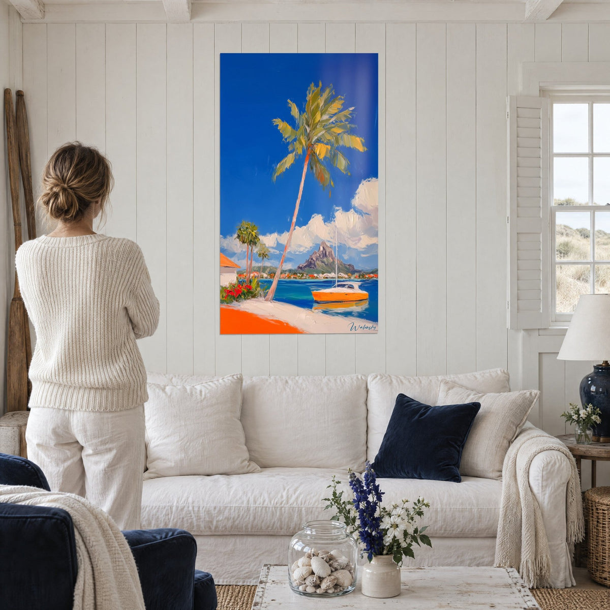Quadro palma inclinata su laguna turchese, veliero arancione e cielo blu cobalto, sopra un divano in un soggiorno luminoso