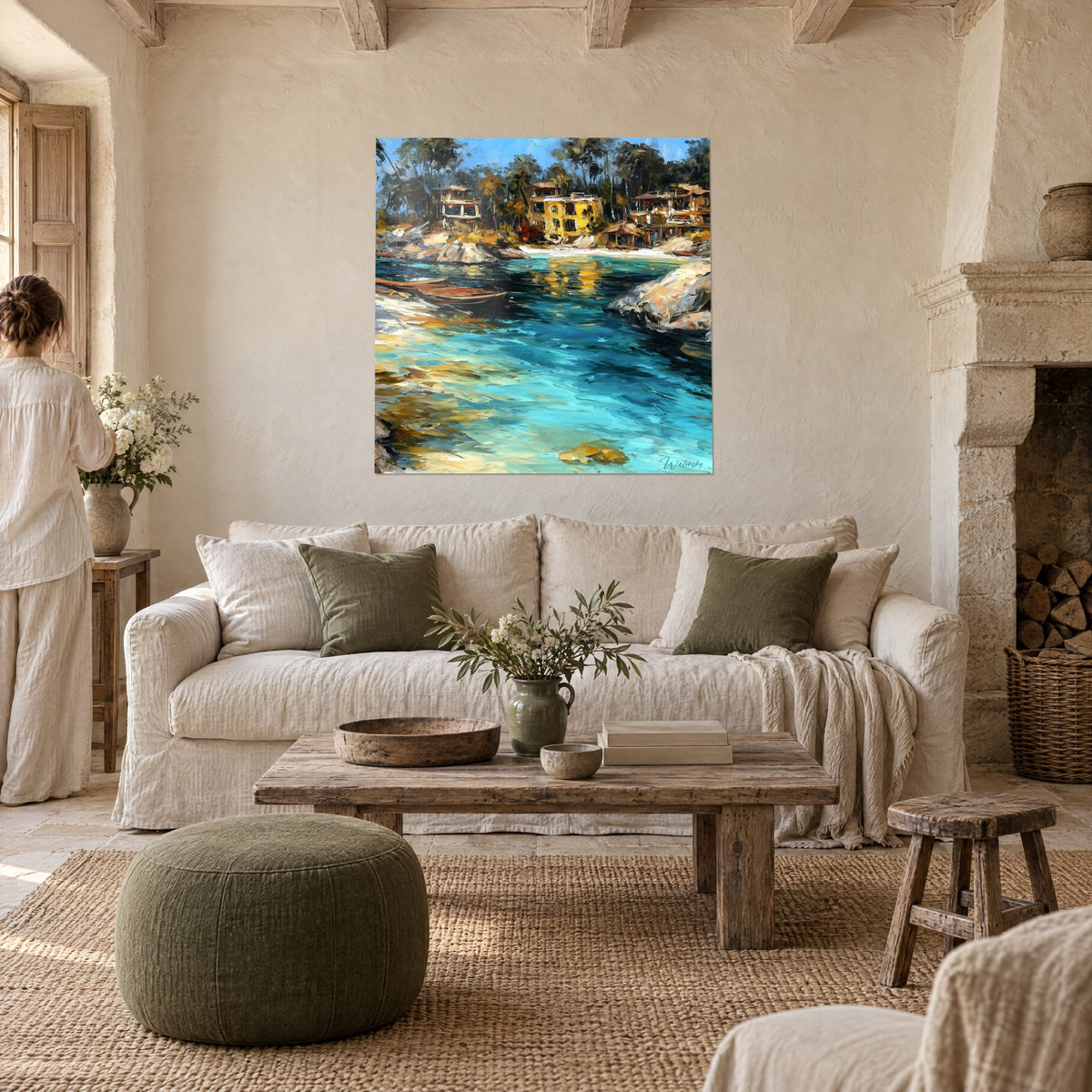 Wall art of a turquoise cove lined with yellow houses, ochre rocks and boats, above a sofa in a bright living room
