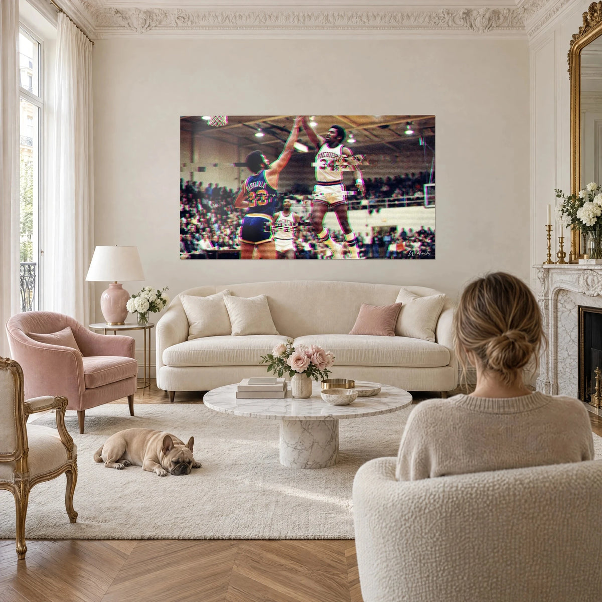 Wall art of two basketball players mid-jump, white number 34 jersey against blue and yellow jersey, above a sofa in a bright living room