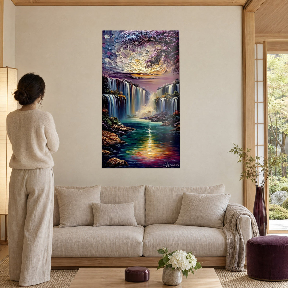 Schilderij van een majestueuze waterval met gouden en paarse wateren, hemel van gebeeldhouwde wolken, vrouw van achteren boven een bank in een lichte woonkamer