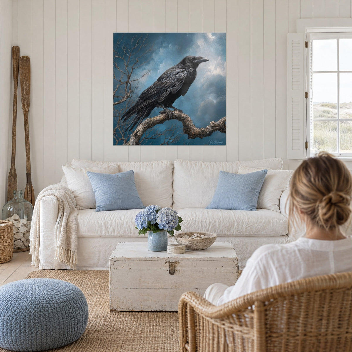 Gemälde Rabe auf knorriger Ast sitzend, stürmisch blauer Himmel, über einem Sofa in einem hellen Wohnzimmer