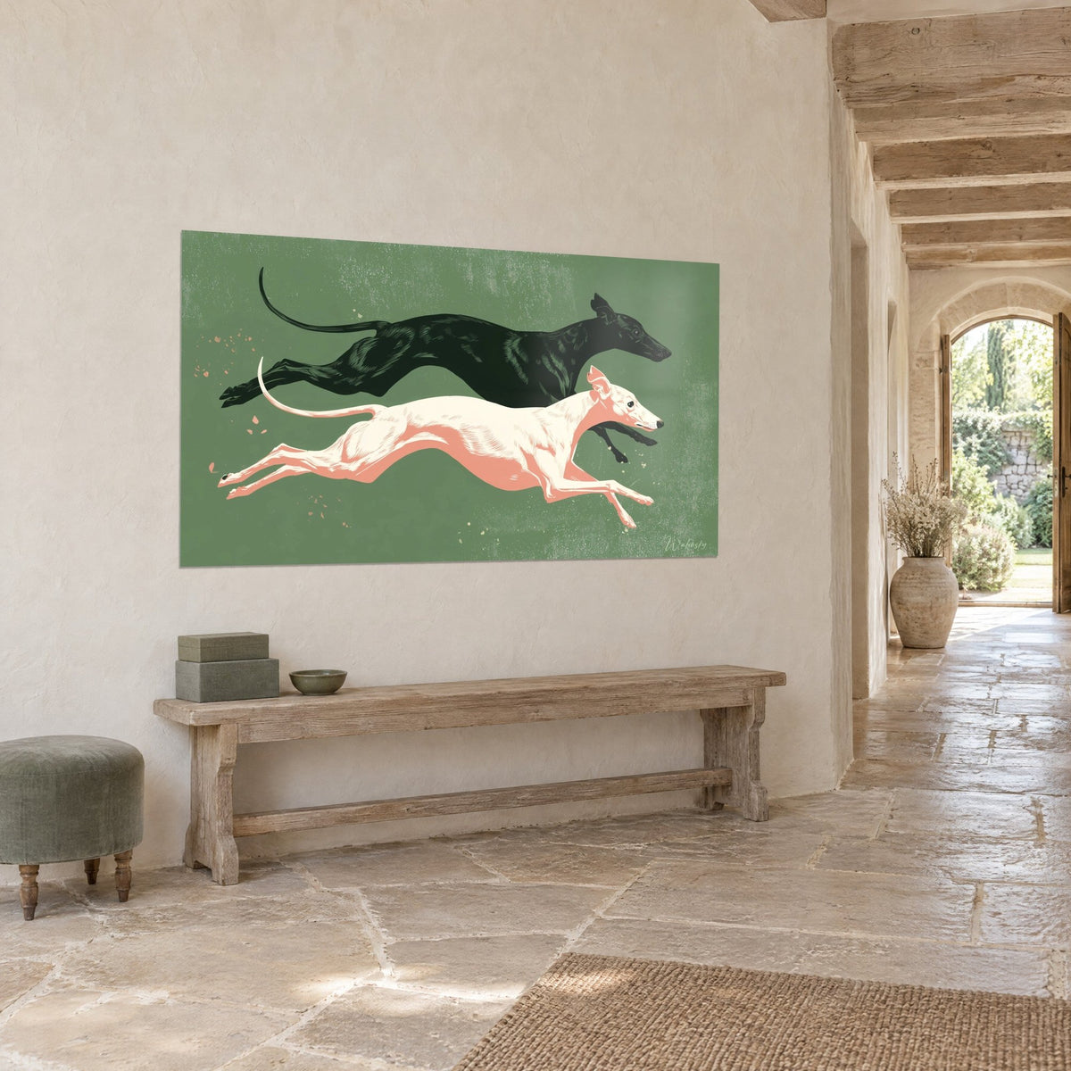 Cuadro dúo de perros esbeltos en plena zancada, pelaje negro tinta y crema rosado sobre verde, pared encalada de una casa de piedra