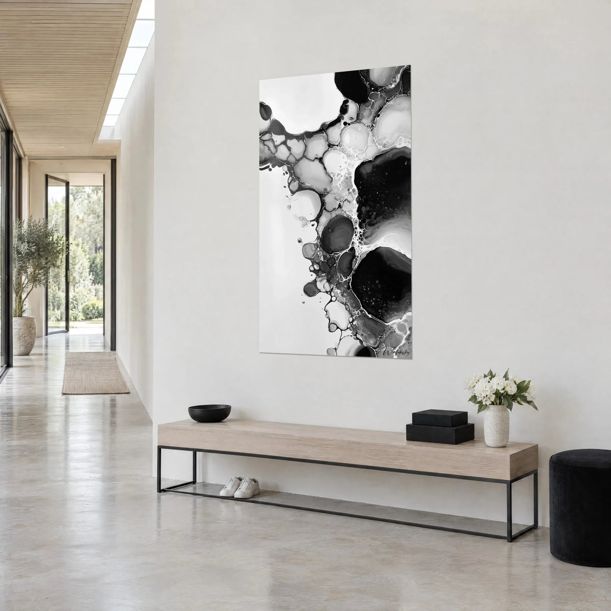 Wall art with abstract bubble foam, large black pockets and white lace, three-quarter view above a wooden bench