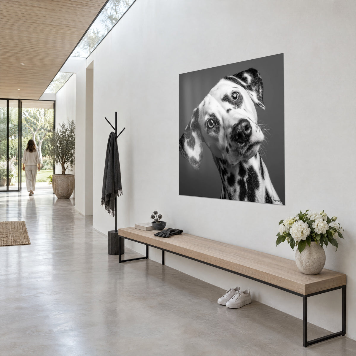 Quadro cane maculato dallo sguardo birichino, musetto nero lucido e orecchie cascanti su grigio antracite, corridoio chiaro in pietra