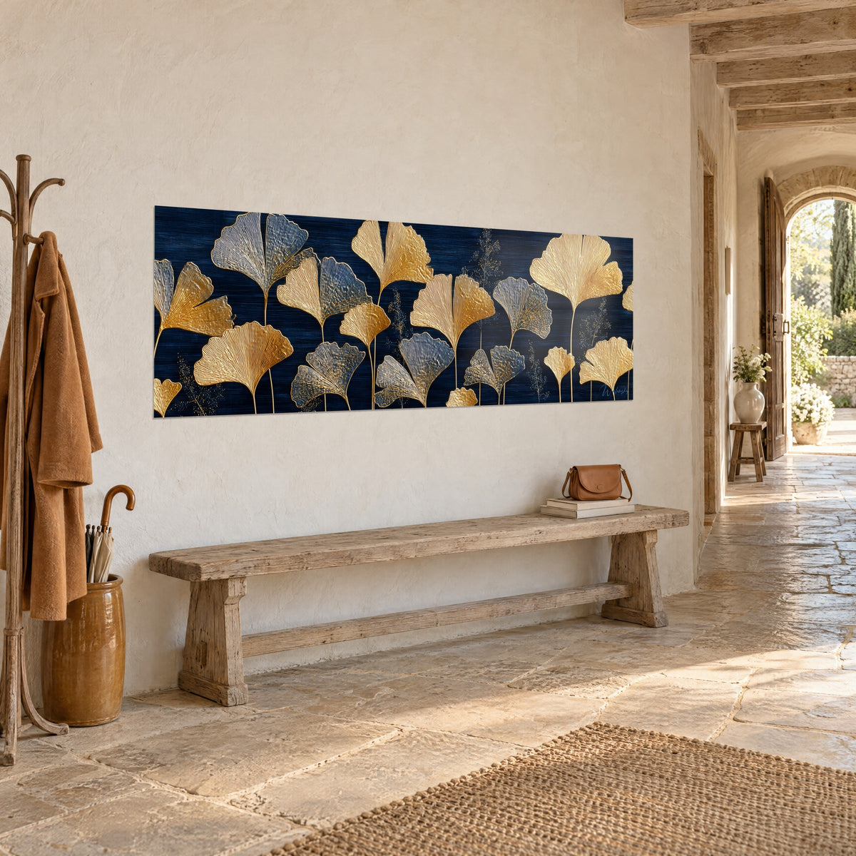 Quadro con foglie a ventaglio cesellate in oro e blu notte in formato panoramico, appeso sopra una panca rustica in pietra antica