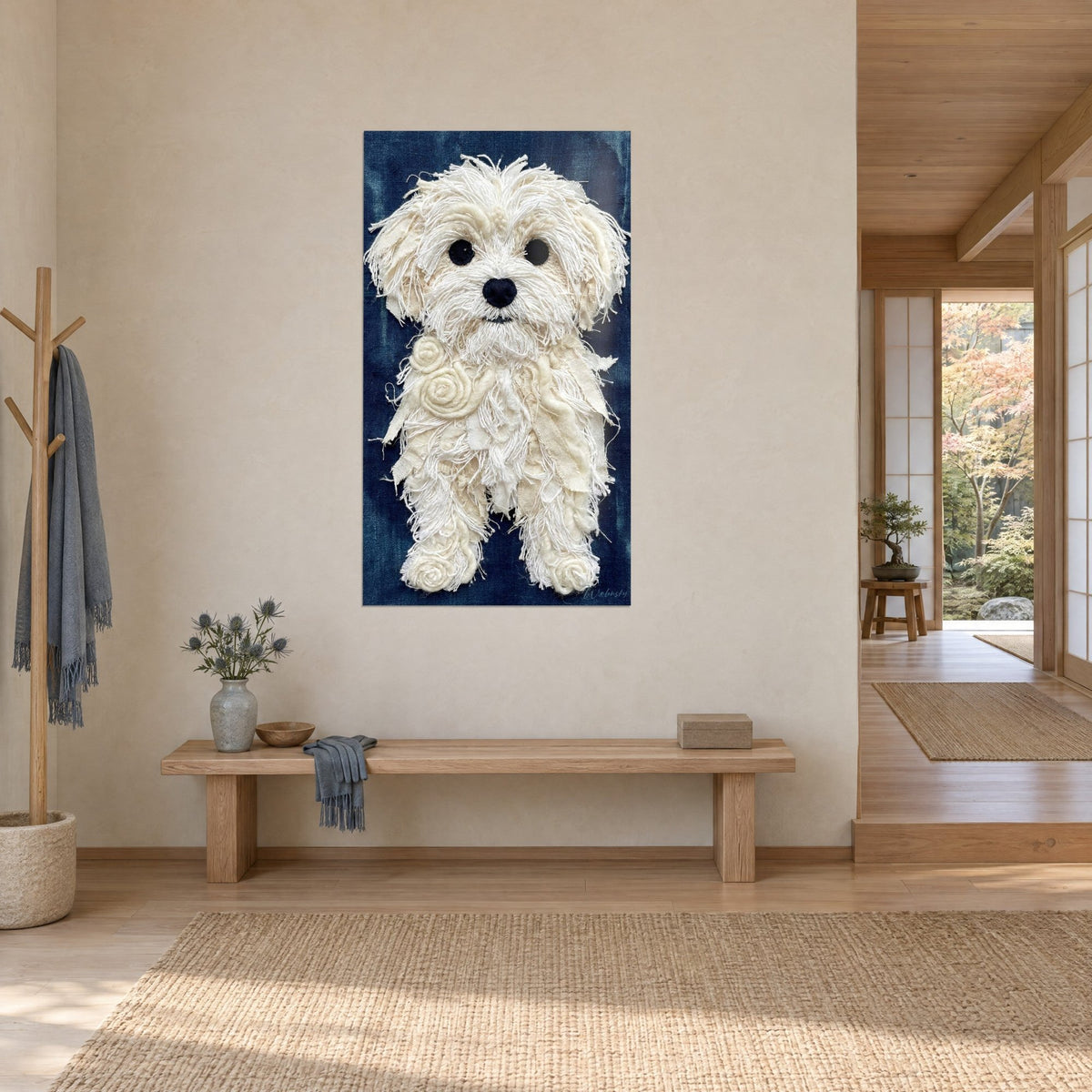 Wall art small white dog in ivory cotton fringes and spiral bows, indigo background, seen at an angle beside a wooden bench