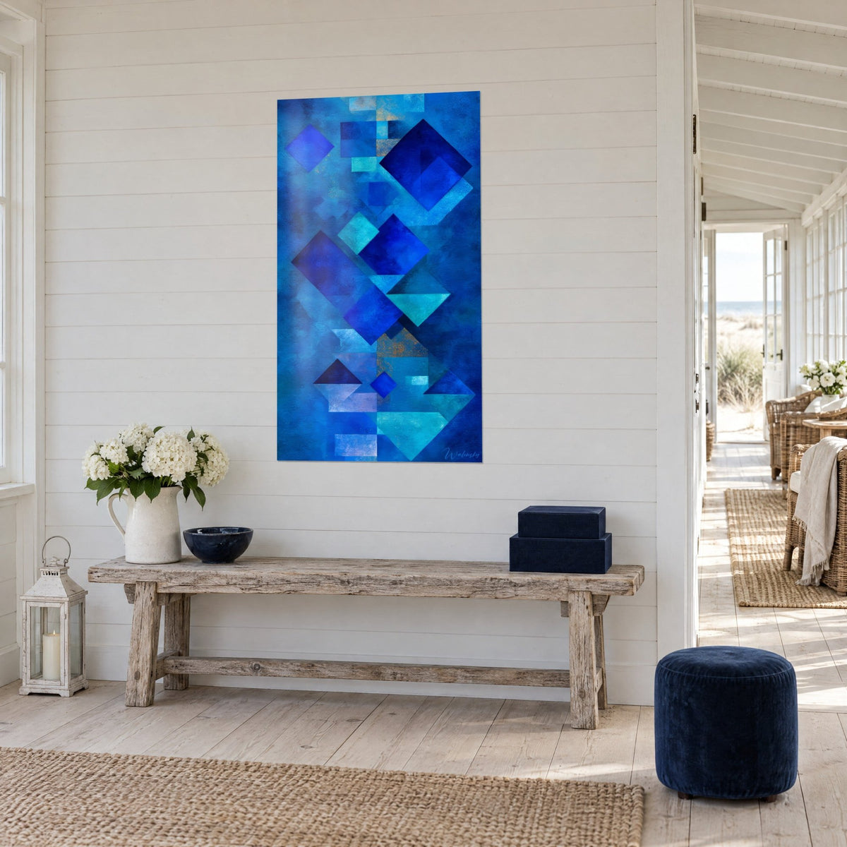 Schilderij mozaïek van indigo en cyaan vierkanten met koperkleurige accenten, verweerd houten console, driekwartzicht, kustsfeer