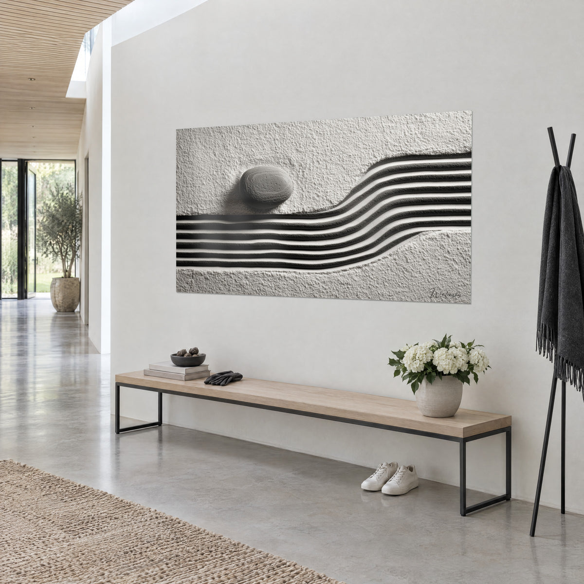 Wall art miniature zen garden, oval grey pebble and black and white sand waves, hung beside a light wood bench