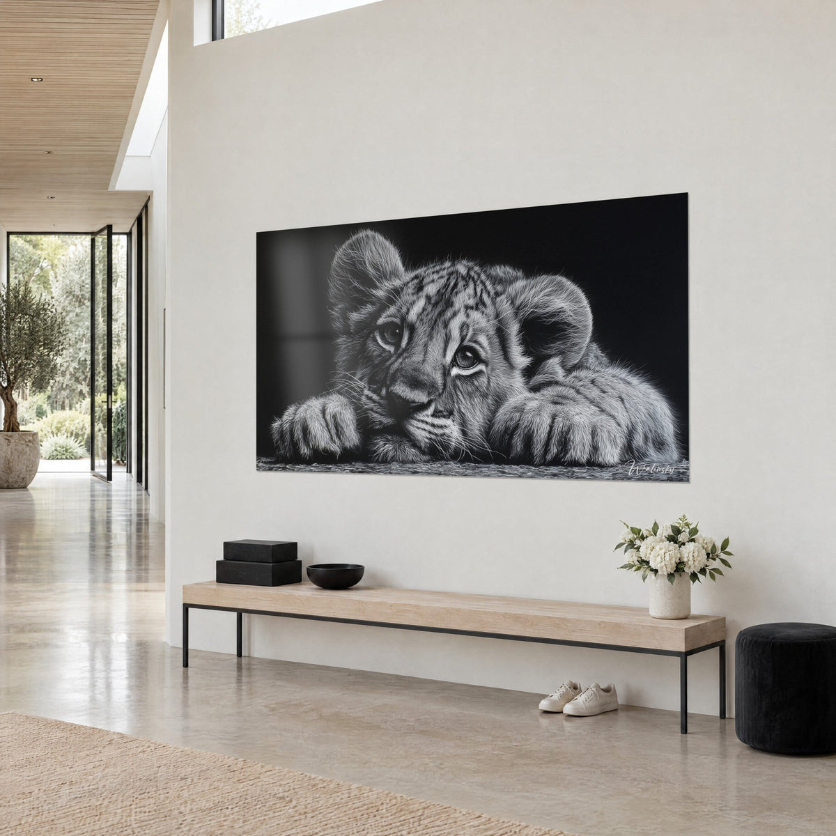 Cuadro joven felino salvaje de pelaje plateado, orejas redondas y rayas finas sobre fondo negro profundo, pared crema, banco de madera clara