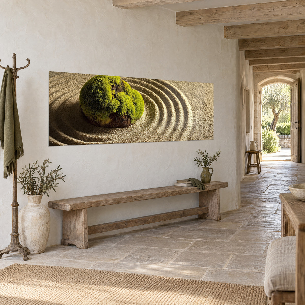 Tableau galet moussu émeraude entouré d'ondulations de sable beige, accroché au mur d'une entrée en pierre dallée