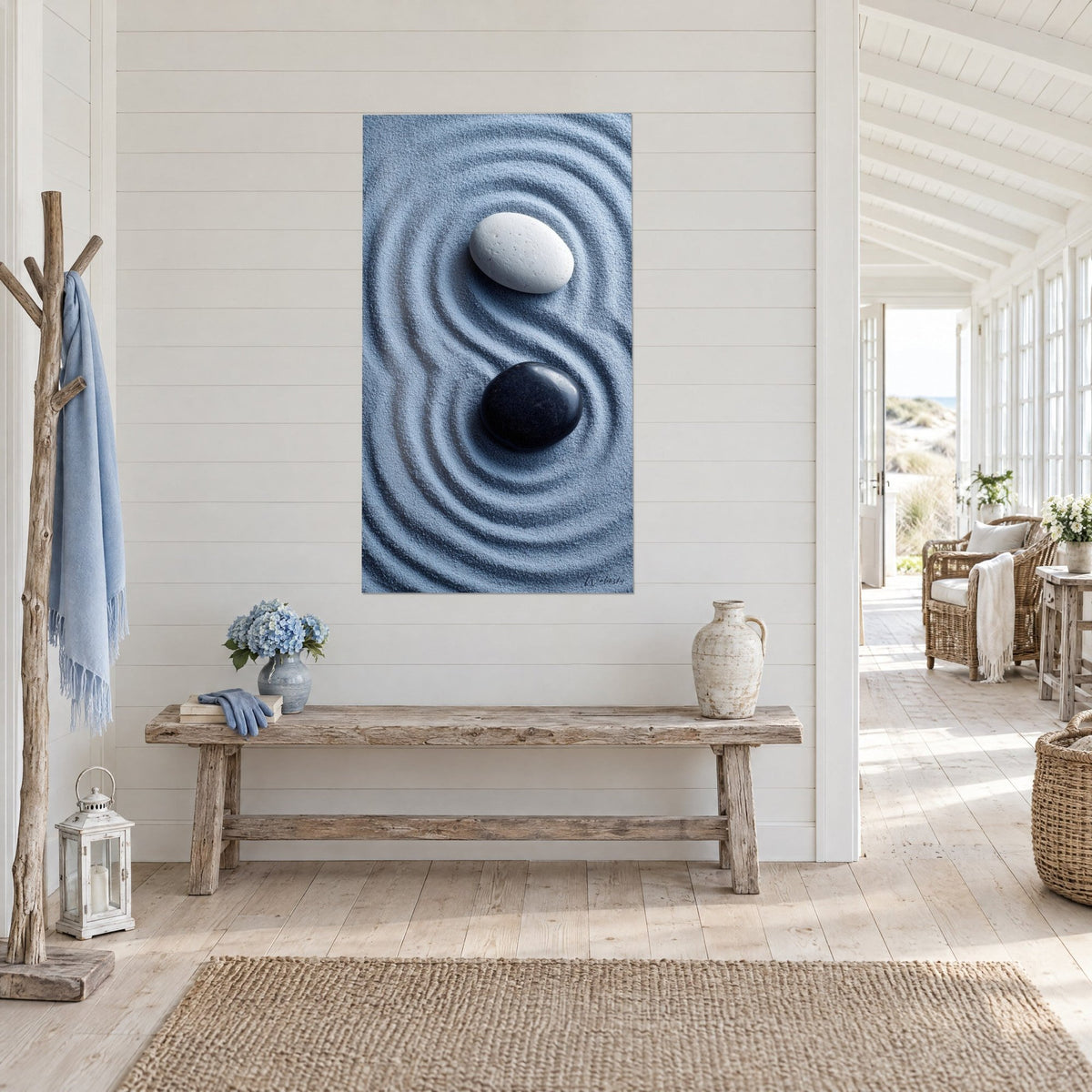 Wall art yin yang in grey-blue raked sand, white and black pebble, raw wood bench, seaside house