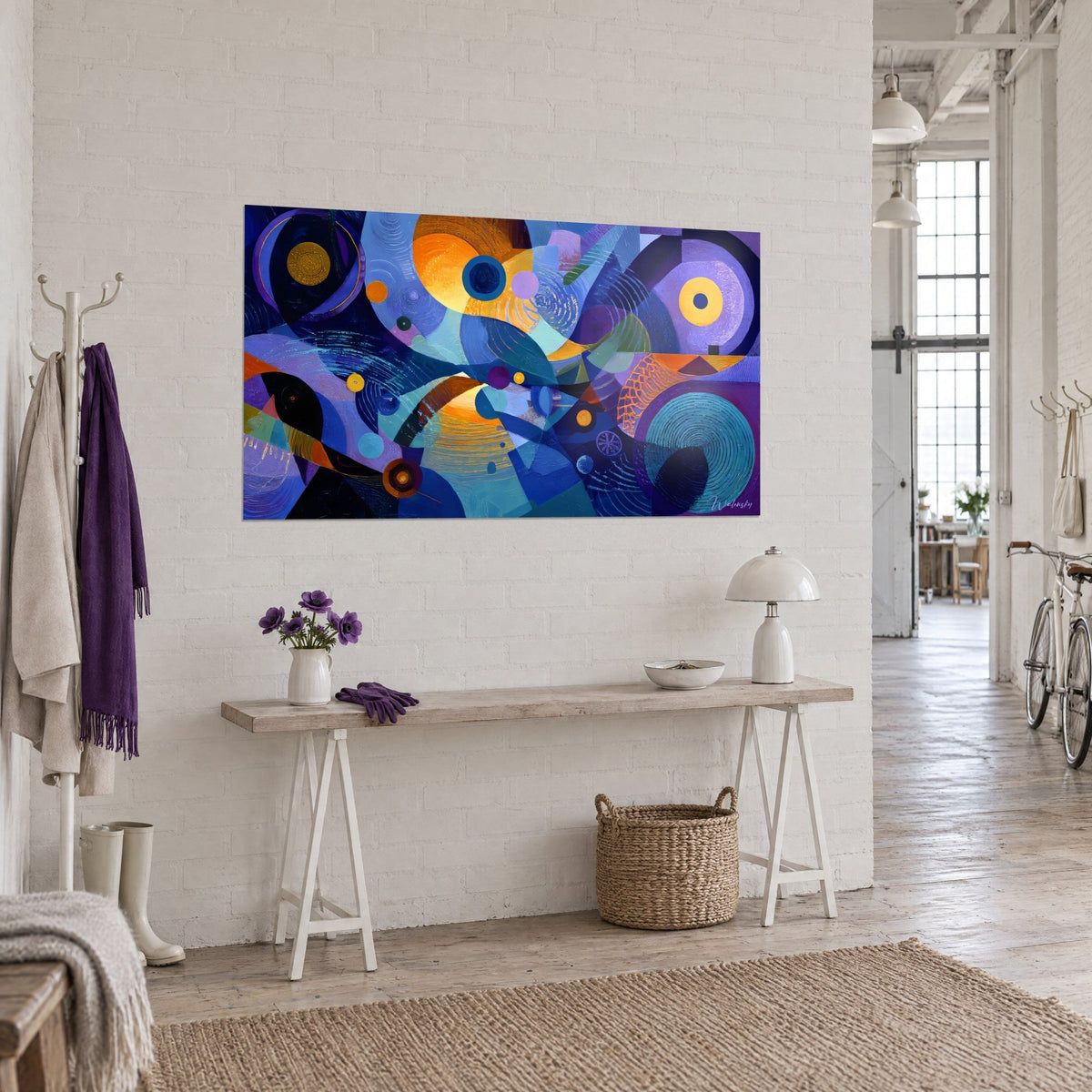 Wall art with a futuristic geometric composition, orange and ochre discs on an indigo background, hung near a wooden console, three-quarter view