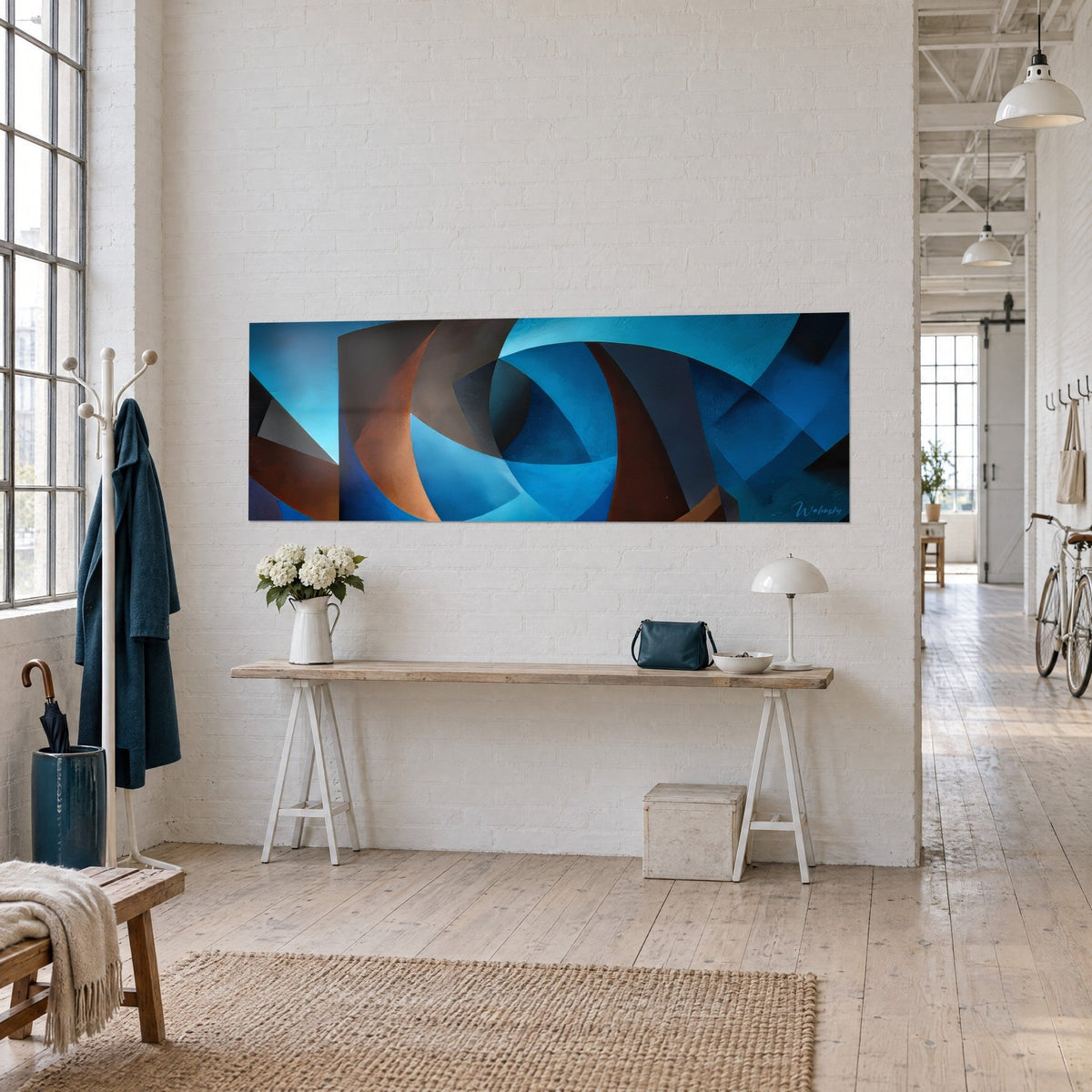 Cuadro arcos geométricos abstractos en cobalto y cobre, colgado sobre una consola de madera en un loft de artista
