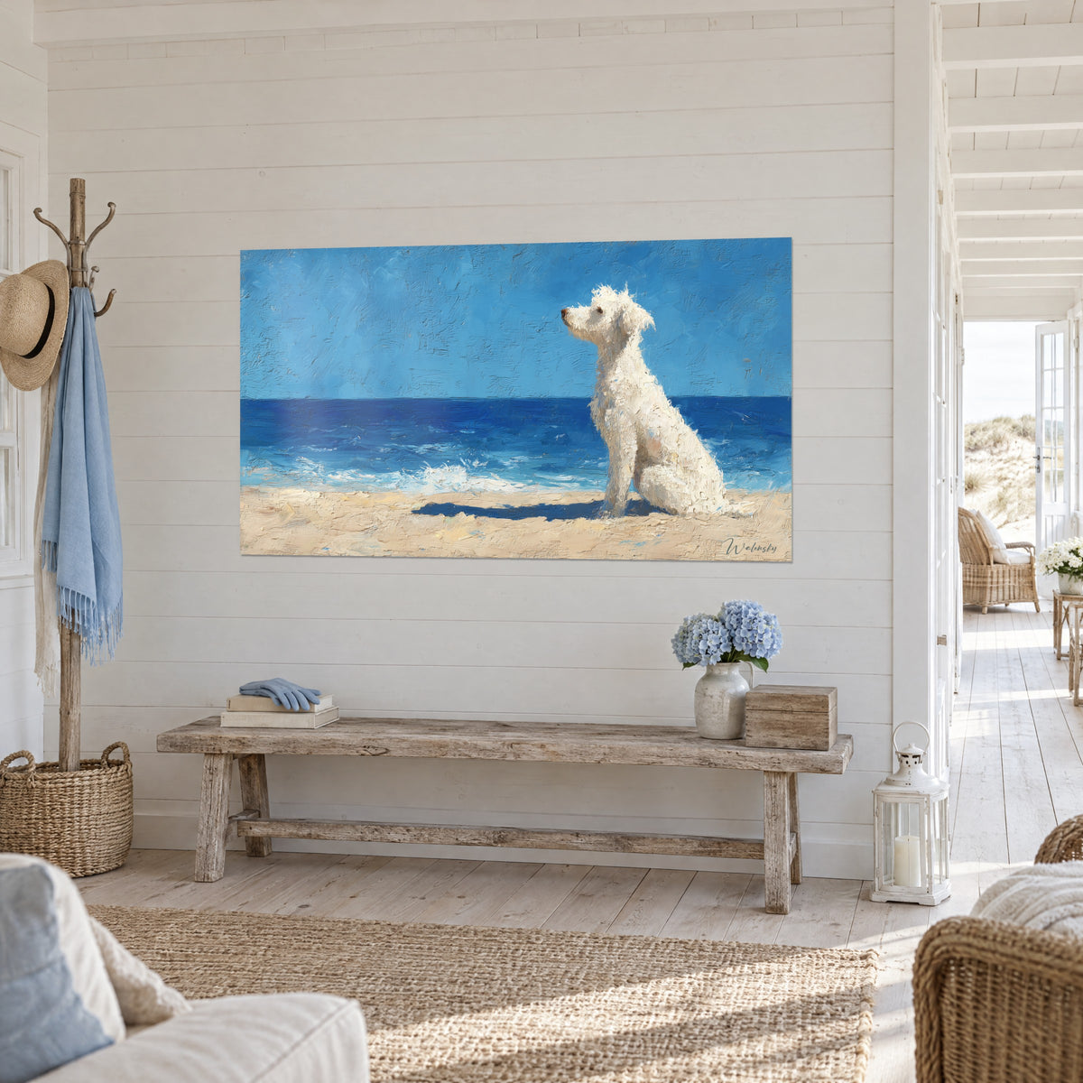 Quadro di un cane color crema con riccioli di colore spesso, mare indaco e cielo azzurro, appeso a una parete a doghe di un ingresso chiaro