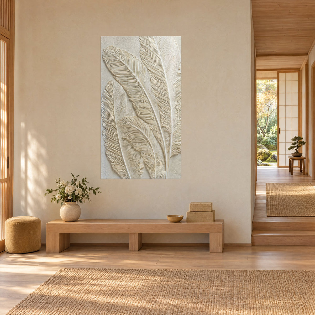 Quadro con tre piume in bassorilievo crema e sabbia, rachidi marcati, parete beige, panca in legno, corridoio aperto sul giardino