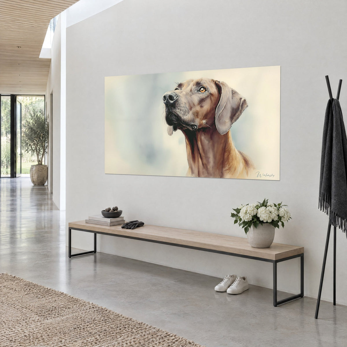 Cuadro de un Rhodesian Ridgeback en acuarela, hocico negro y pelaje cobrizo, fondo crema, en la pared de una casa de arquitecto