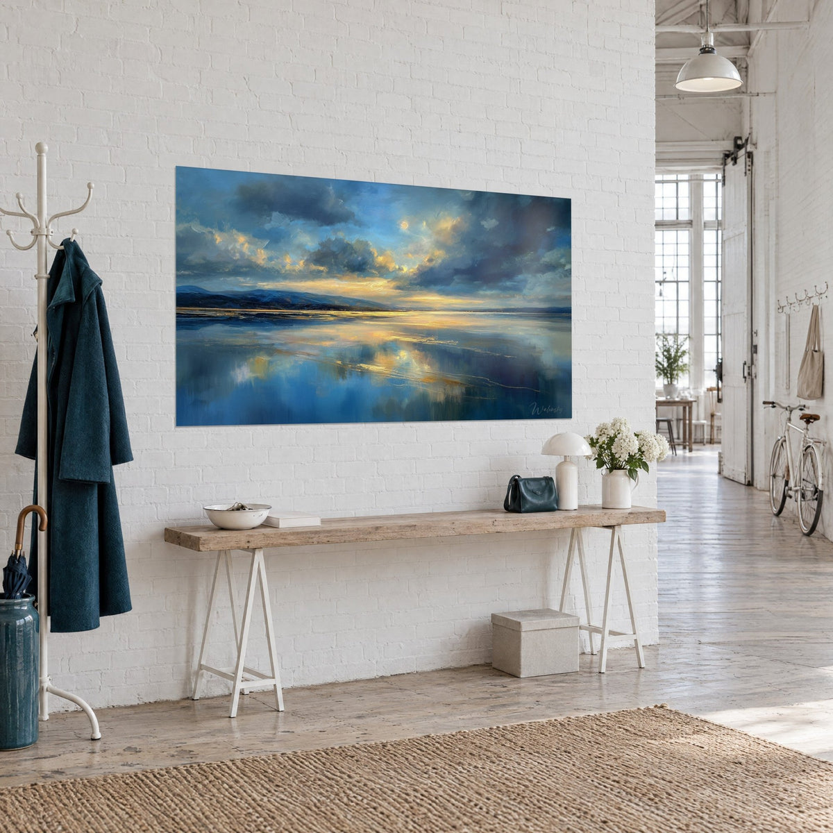 Wall art mirror-like expanse of water beneath a steel-blue and amber stormy sky, dark hills on the horizon, on a white brick wall