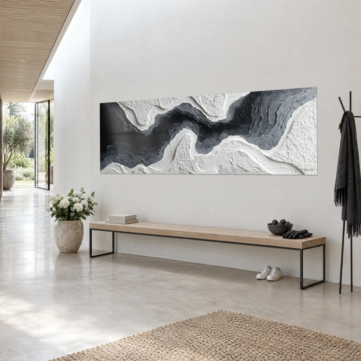 Cuadro de olas abstractas negras y plateadas en empastes crema, de tres cuartos, sobre un banco de madera clara