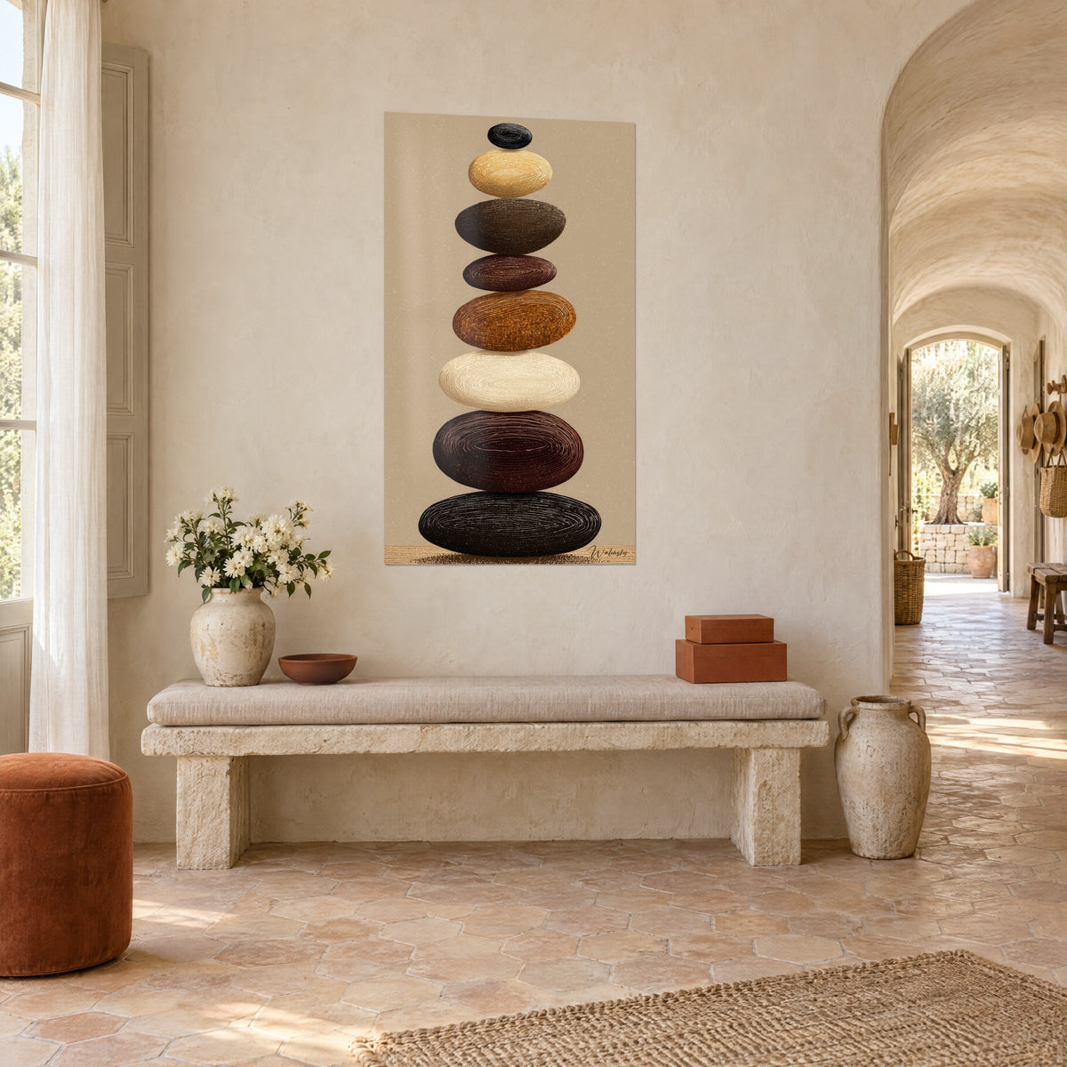 Quadro torre di pietre lisce color crema, rame e marrone profondo, striature concentriche, sul muro imbiancato di un ingresso provenzale