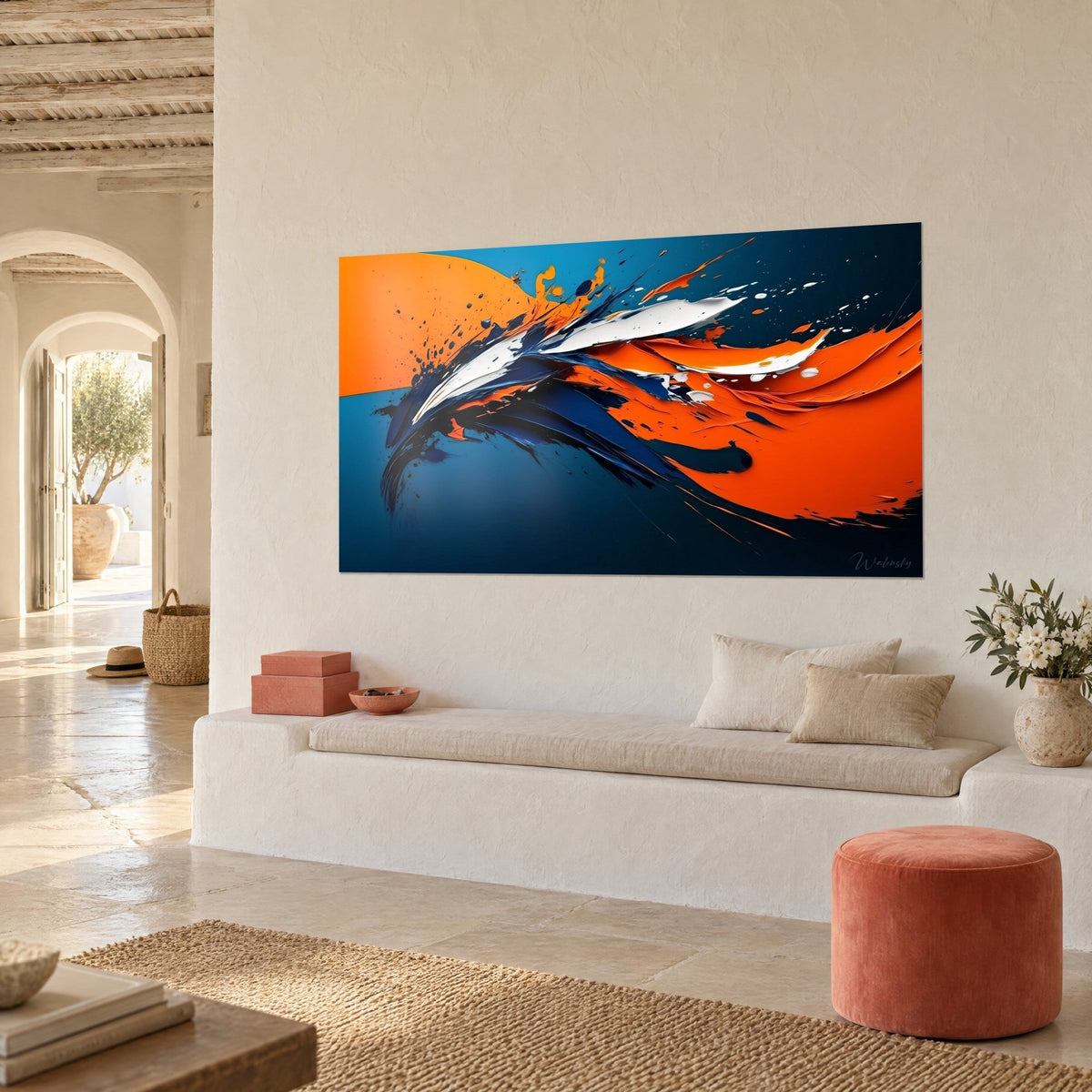 Wall art with an explosion of white paint, vivid orange and midnight blue, three-quarter view, white banquette and coral pouf, whitewashed wall