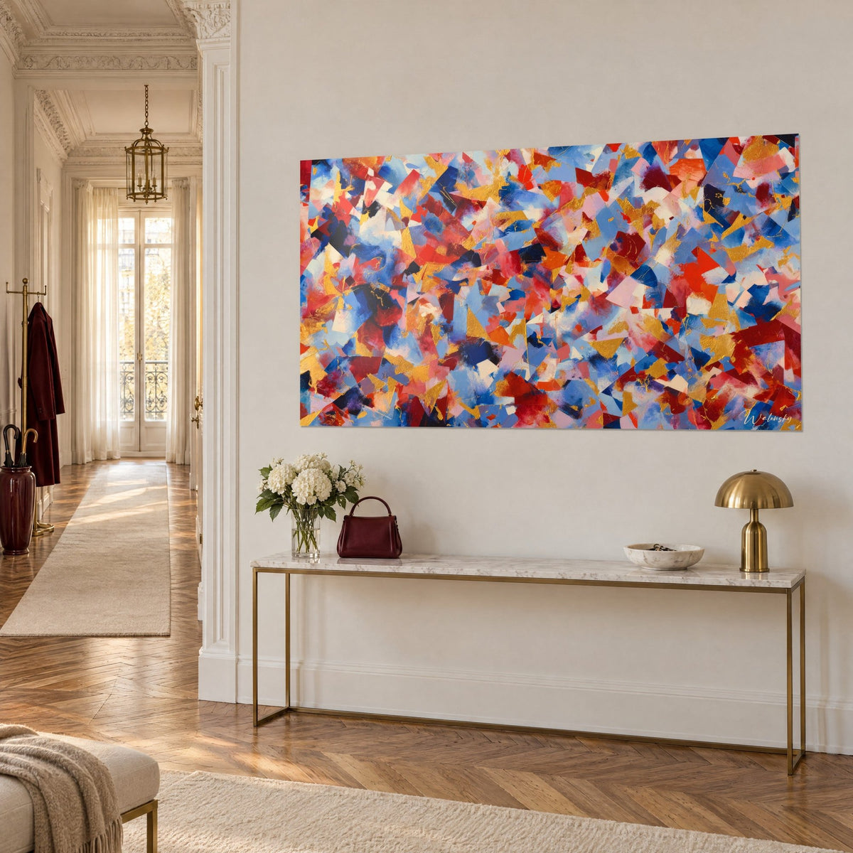 Tableau symphonie de facettes cobalt et vermillon rehaussées d'or, sur un mur blanc au-dessus d'une console dorée haussmannienne