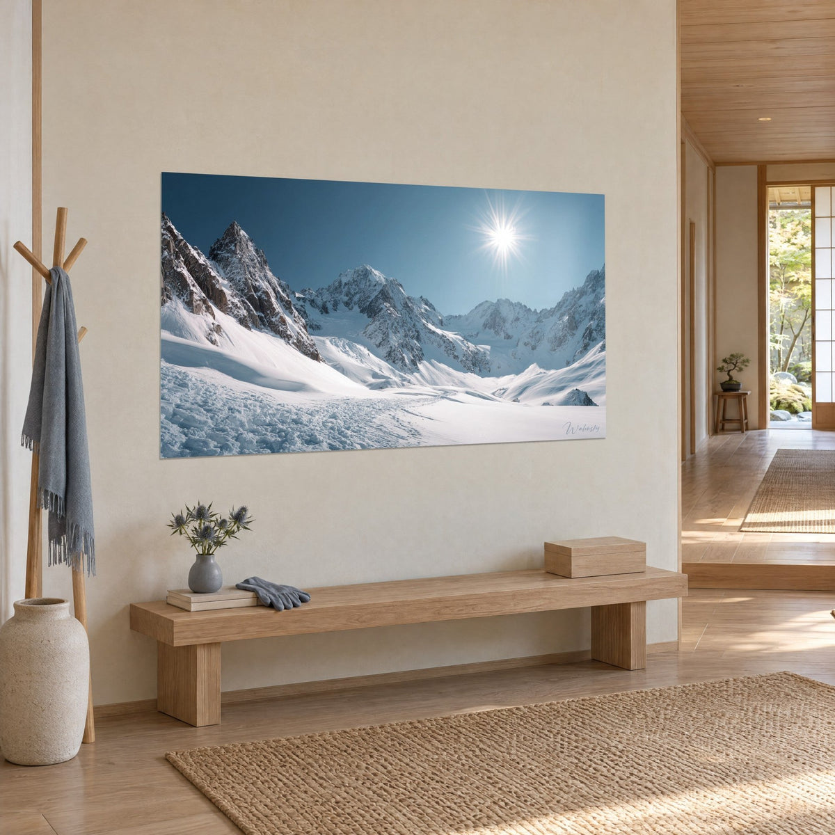 Cuadro de un glaciar soleado con crestas rocosas marrones y nieve deslumbrante, colgado en la pared beige de un recibidor japandi