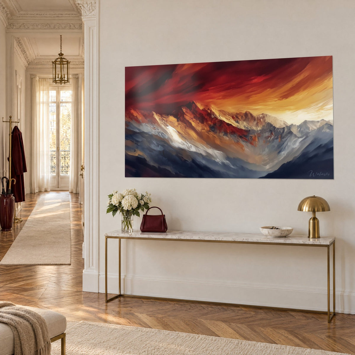 Wall art mountain range with ochre and grey-blue slopes, carmine red sky, on a cream wall, gilded console in the entrance hall