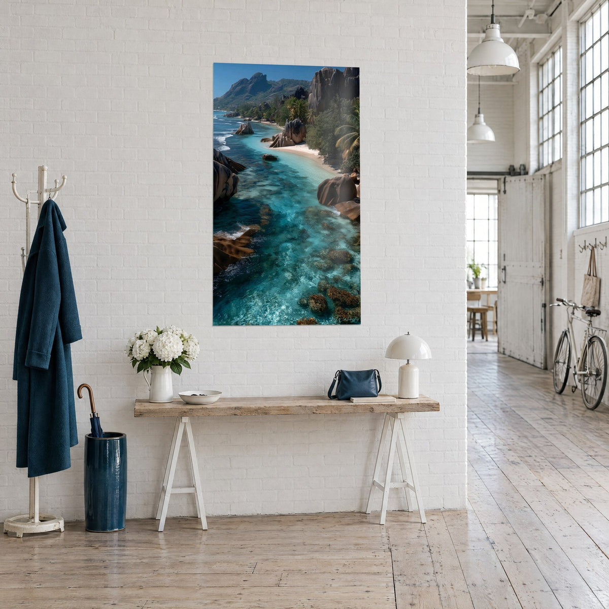 Tableau lagon cristallin aux rochers ocre et palmiers verts, vu de trois quarts sur un mur blanc, loft d'artiste