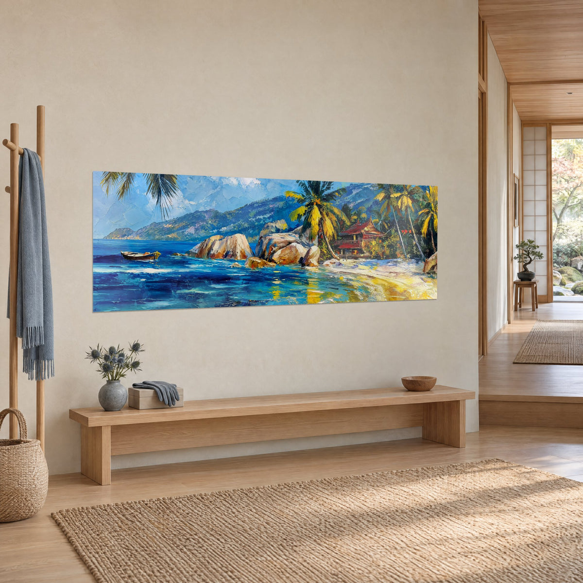 Quadro di una baia paradisiaca, rocce ocra e mare turchese dipinto a spatola, appeso in un corridoio japandi di tre quarti
