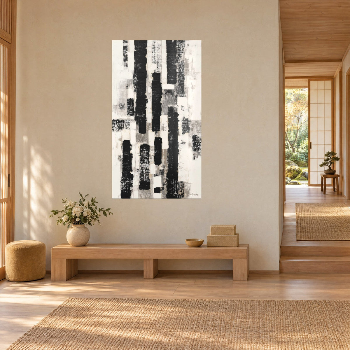 Quadro con strisce verticali di inchiostro nero su fondo avorio, tocchi grigi, parete beige, panca in legno chiaro e tappeto intrecciato