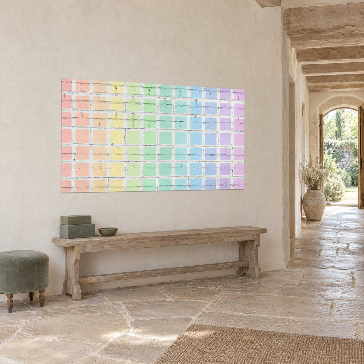 Schilderij regenboog van pastelkoraal, mintgroene en lila vierkanten op gekalkte baksteen, driekwart zicht in een stenen hal