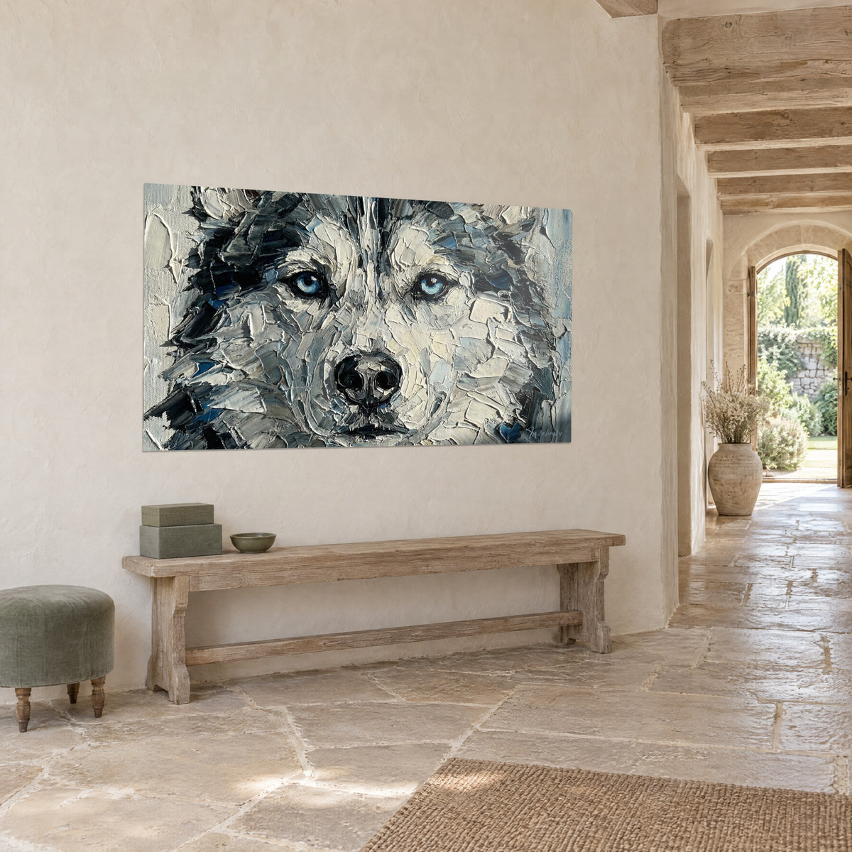 Gemälde eines weißen Wolfs mit azurblickenden Augen, Spachtelstriche in Cremeweiß und Anthrazit, an einer hellen Steinwand über einer Holzbank