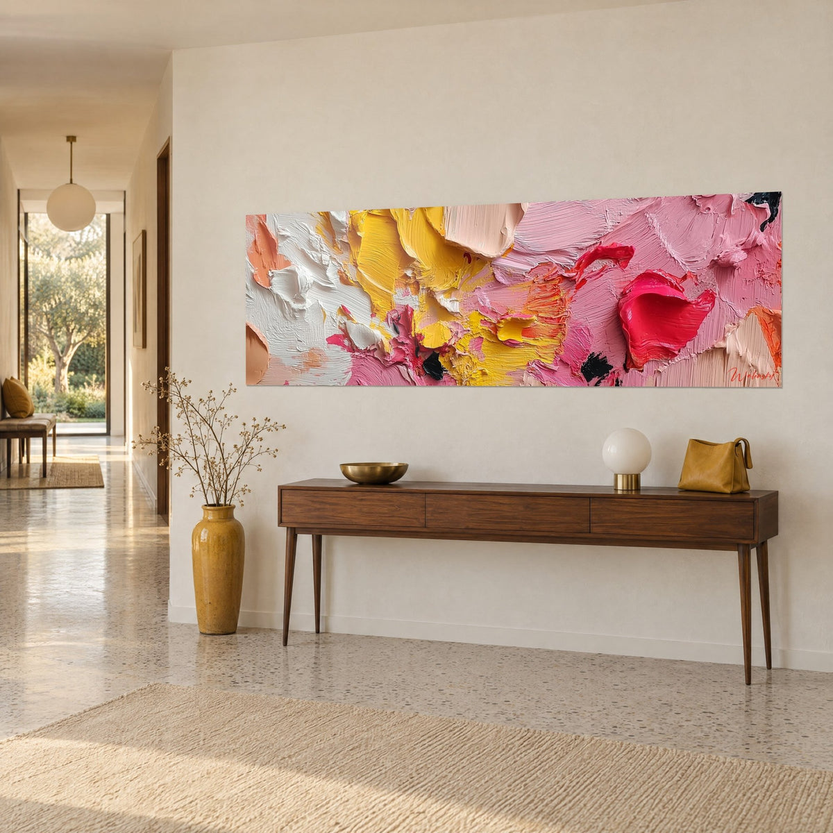Schilderij met een explosie van boterkleurig geel, bubblegumroze en koraal pigmenten, opgehangen boven een donkere houten console in de hal uit de jaren 50