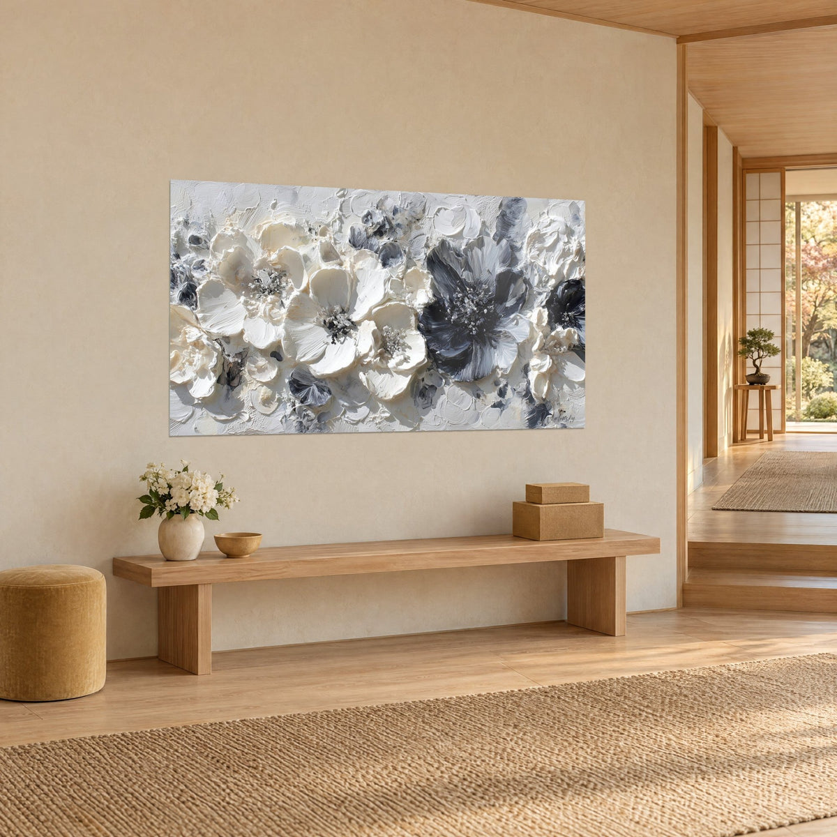 Tableau bouquet de fleurs sculptées à la spatule, pétales ivoire et corolle charbon, accroché au mur beige d'un couloir japandi