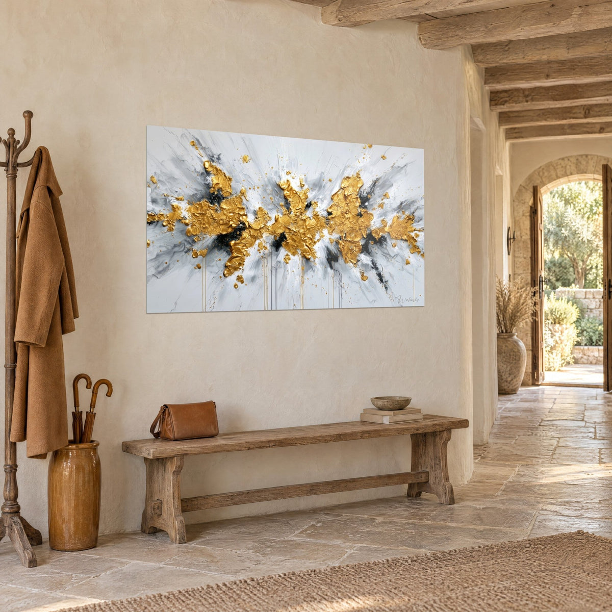 Wall art thick gold splash streaked with black and pearl grey, hung in the stone entrance hall of a country house