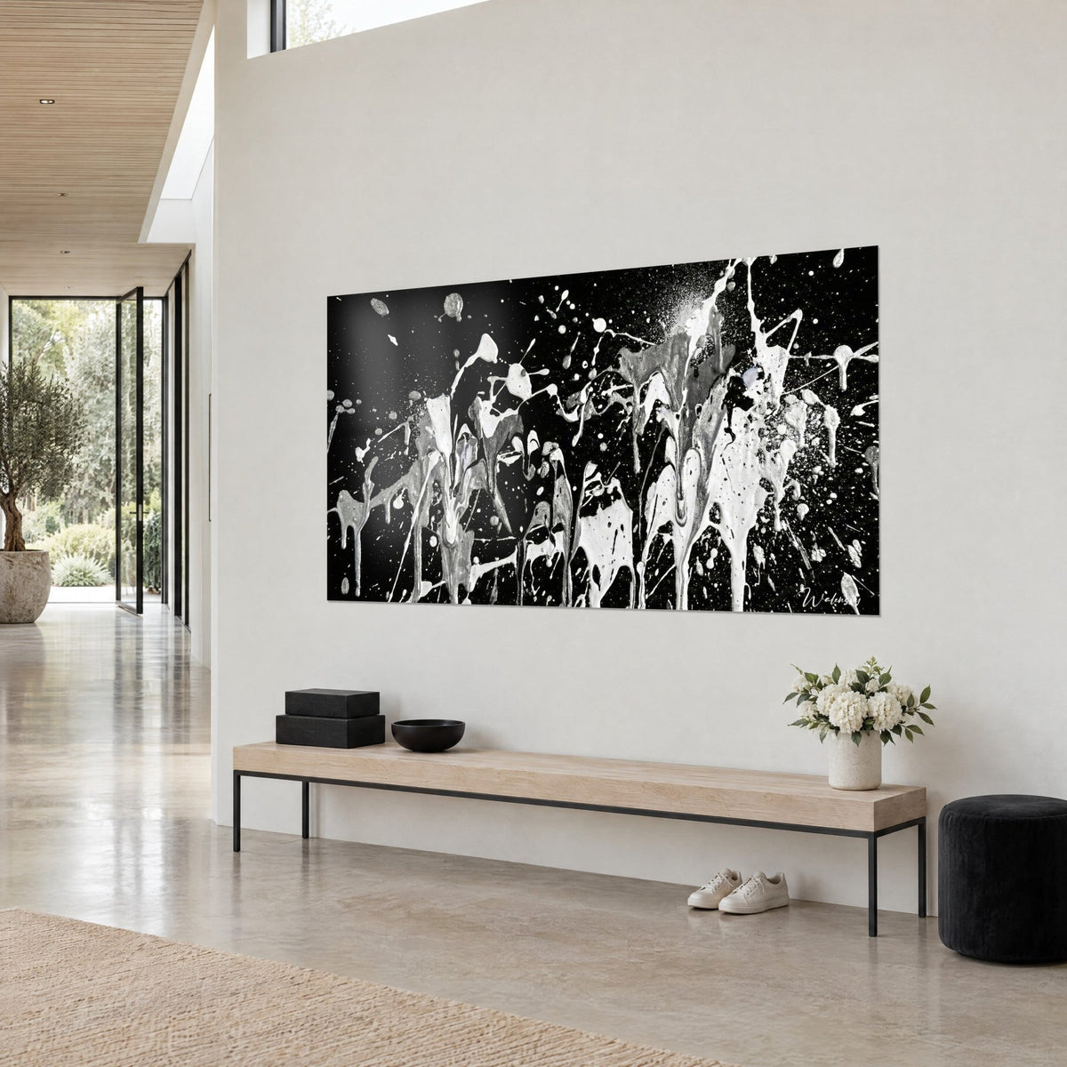 Wall art dripping paint explosion in white and metallic grey on deep black, streams of droplets, hung above a light wood bench