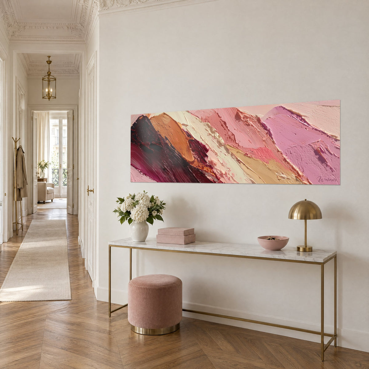 Tableau paysage abstrait de crêtes roses et orangées, relief épais, sur une console dorée dans un couloir haussmannien