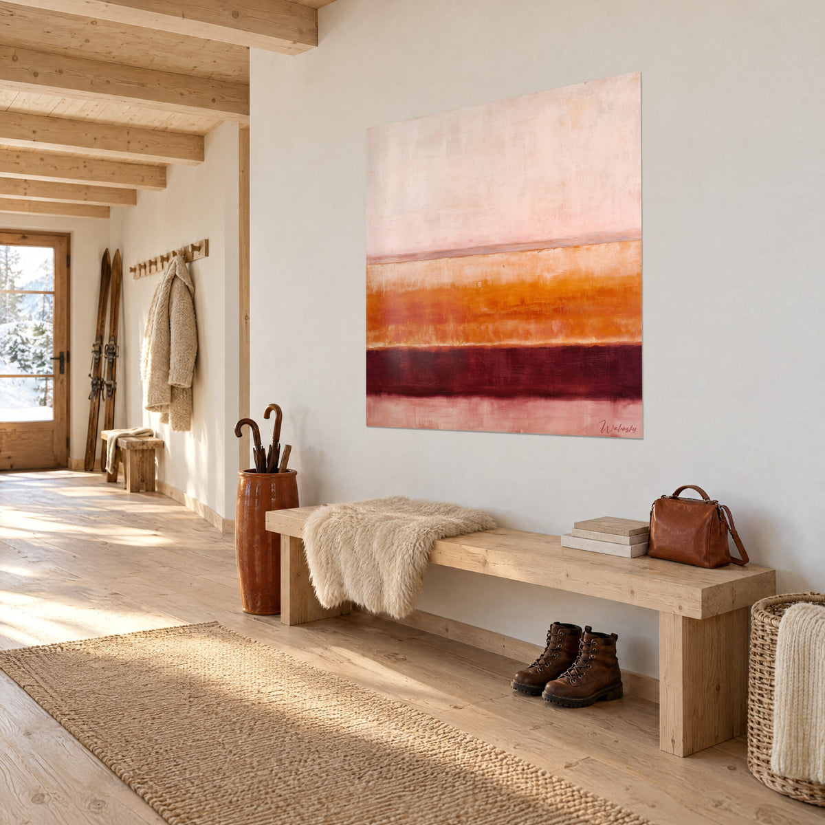 Wall art earth layers in powdered pink, amber and deep burgundy, three-quarter view above a wooden bench in a chalet entrance
