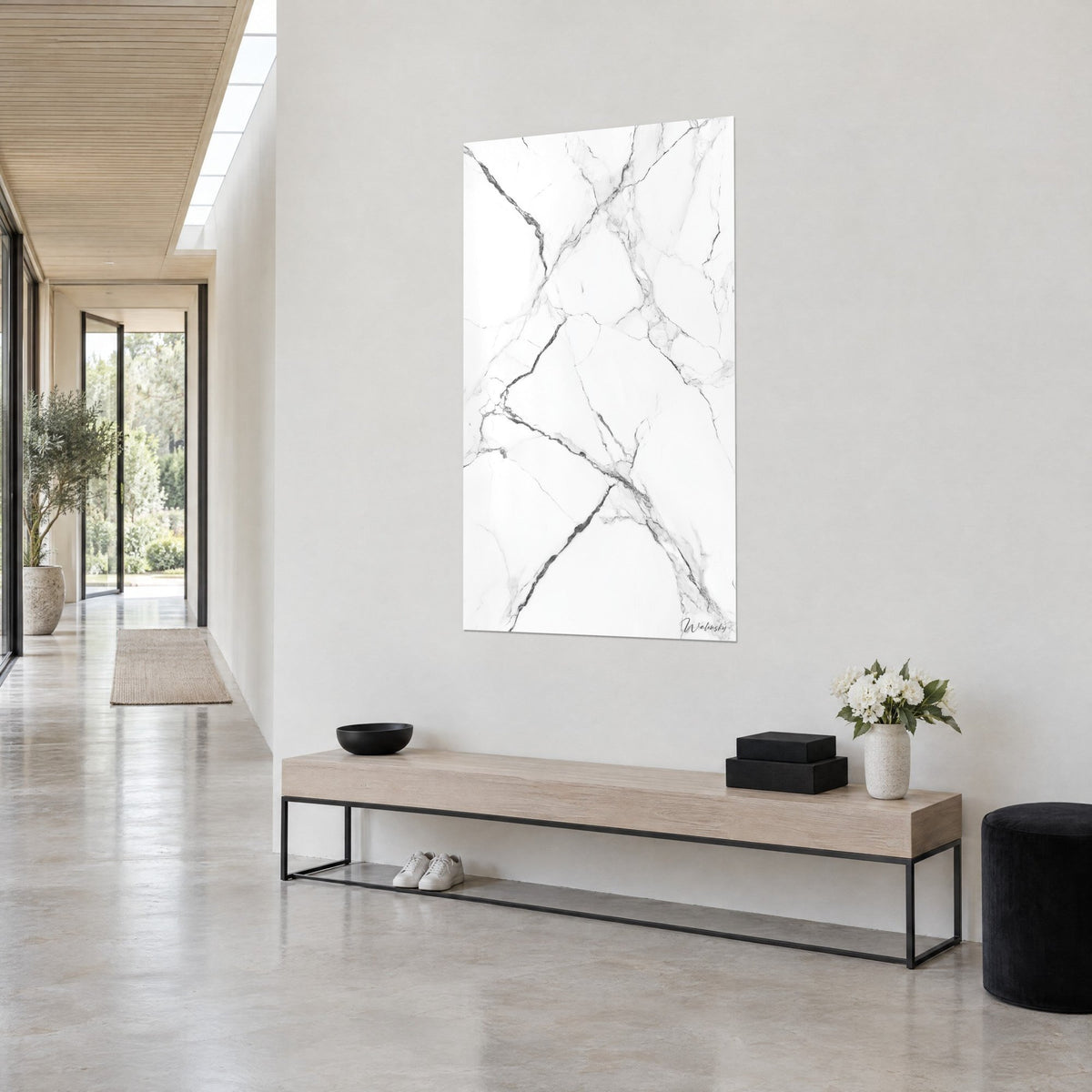 Tableau pierre immaculée striée de fines fissures grises et noires, vue de trois-quarts, couloir clair et banc bois