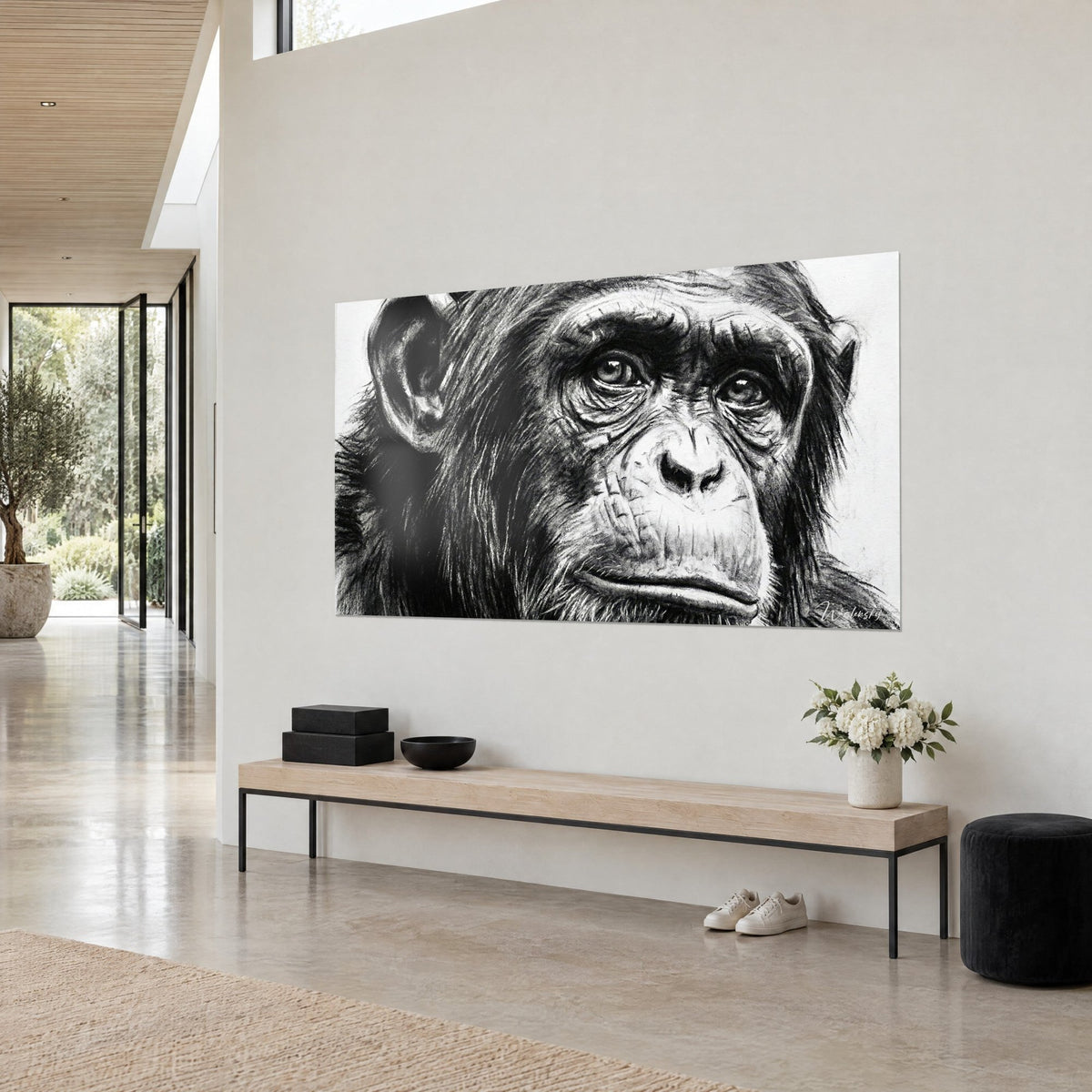 Cuadro rostro de mono con arrugas profundas, pelaje negro carbón sobre fondo blanco crema, visto de tres cuartos en una habitación de madera clara y hormigón